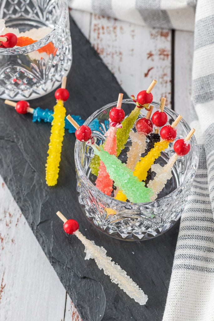 glass cup filled with colorful rock candy skewers