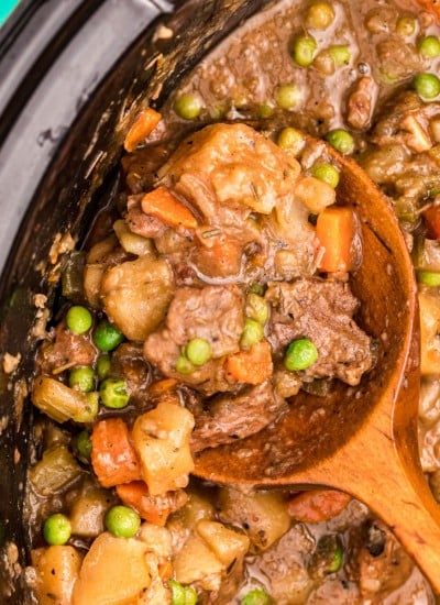 closeup of spoon scooping out slow cooker beef stew from a crockpot