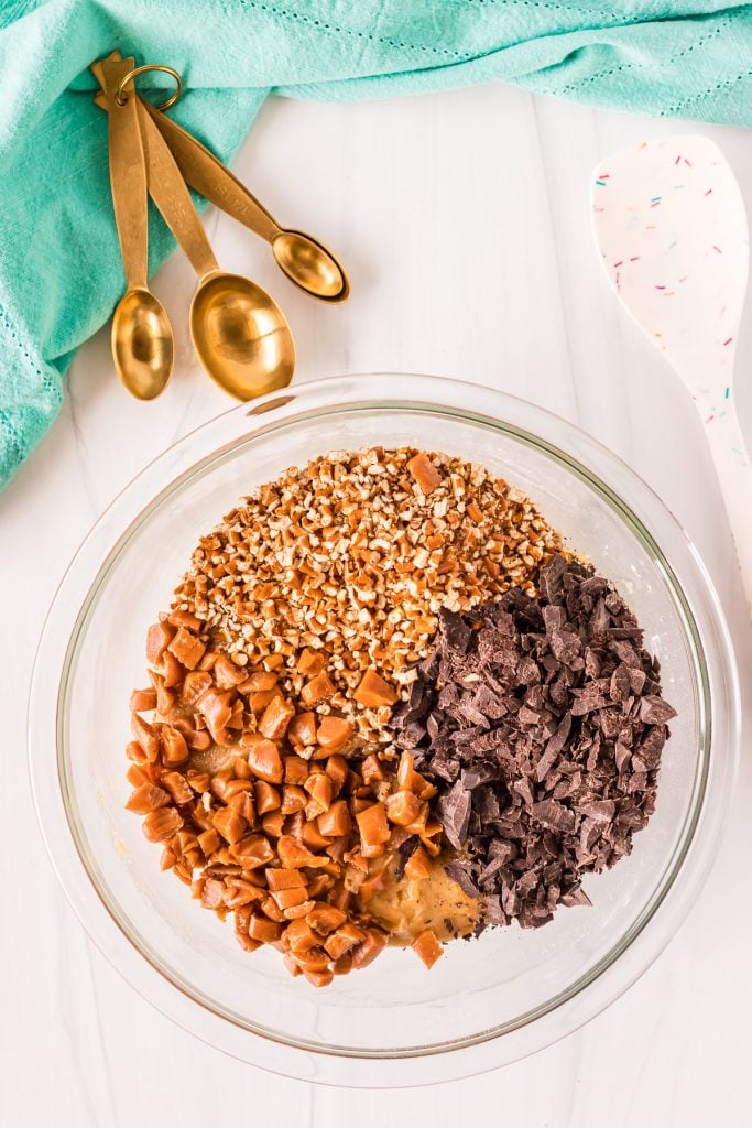 overhead shot of mixing bowl with chocolate, caramels, and pretzels