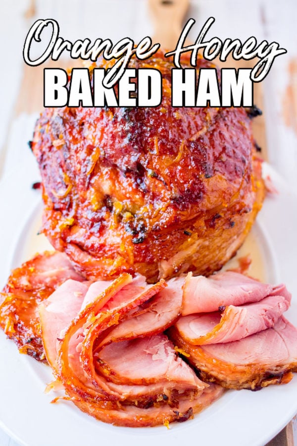 spiral sliced ham on a platter with text reading "orange honey baked ham"