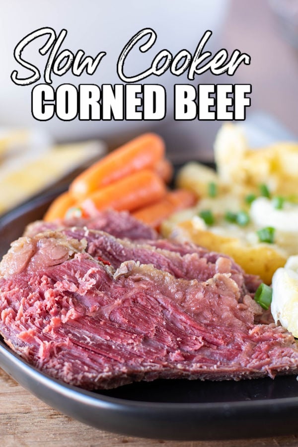 plate of corned beef and veggies with text overlay reading "slow cooker corned beef"