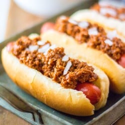 platter of hot dogs topped with chili and onions