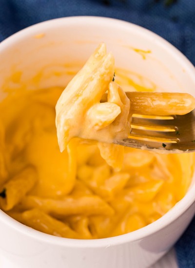 bite of mac n cheese on a fork from a mug