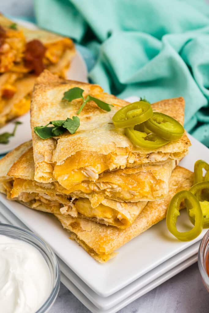 stack of quesadillas topped with sliced jalapenos.