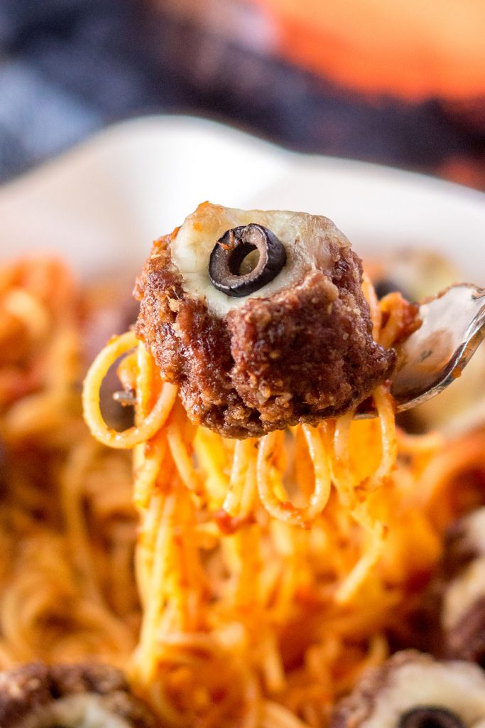spooky olive eyeball meatball and pasta on a fork