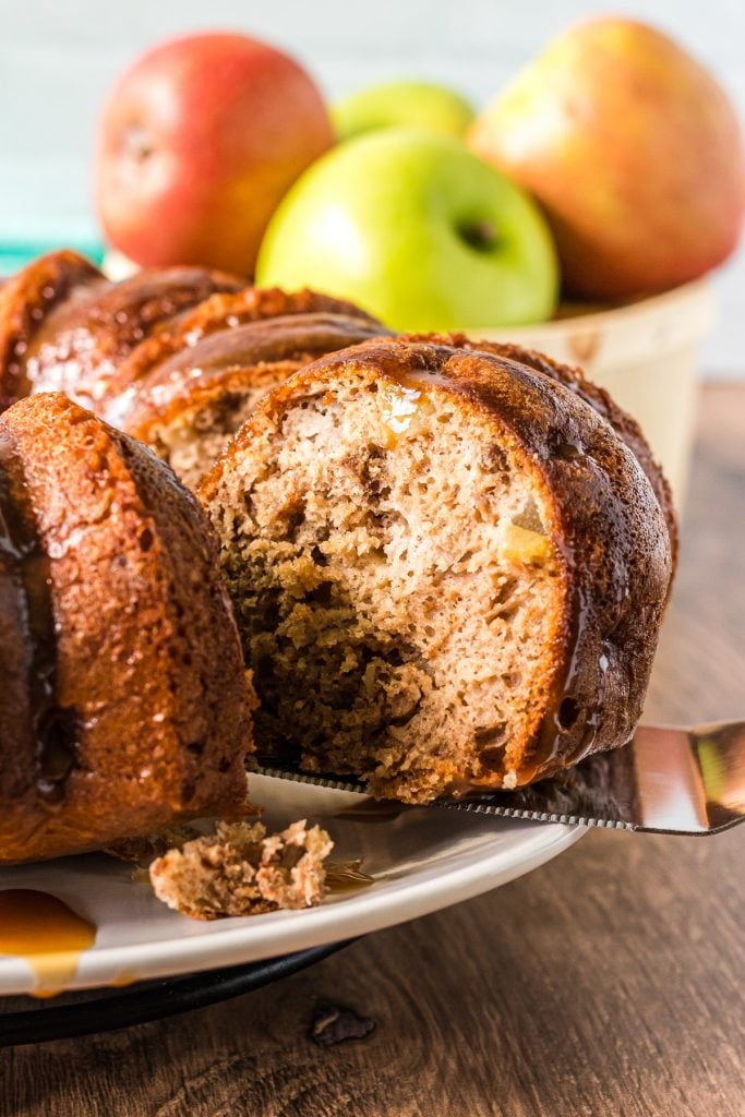 server removing a slice of cake from an apple bundt cake