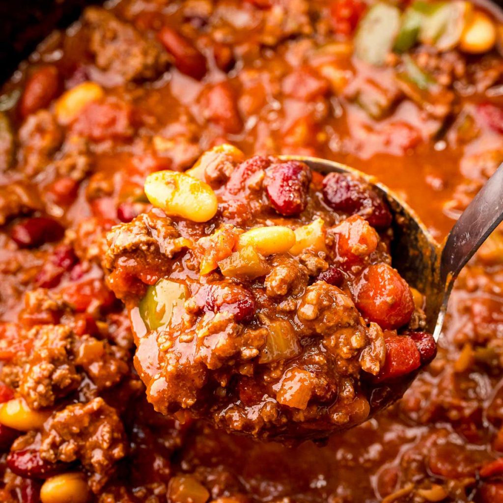 ladle scooping chili from a slow cooker