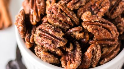 closeup shot of candied pecans in a white bowl