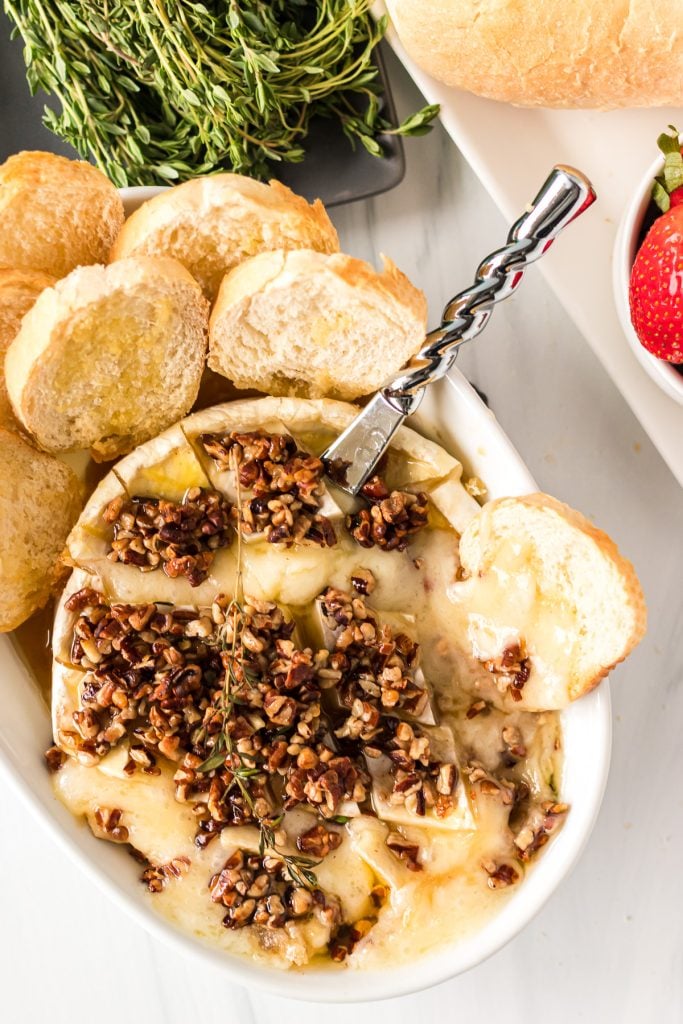 cheese knife dipped into melty baked brie