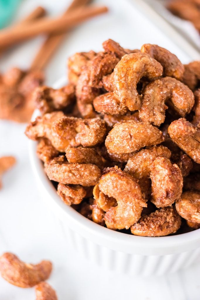 close up of candied cashews in a white bowl