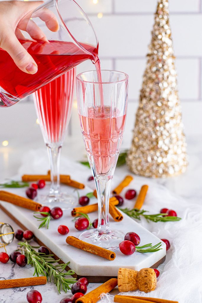 cranberry juice pouring into a champagne flute making a mimosa