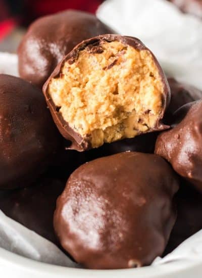 bowl of chocolate covered peanut butter balls with a bite taken out of one