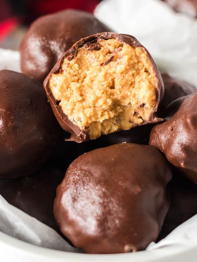 bowl of chocolate covered peanut butter balls with a bite taken out of one
