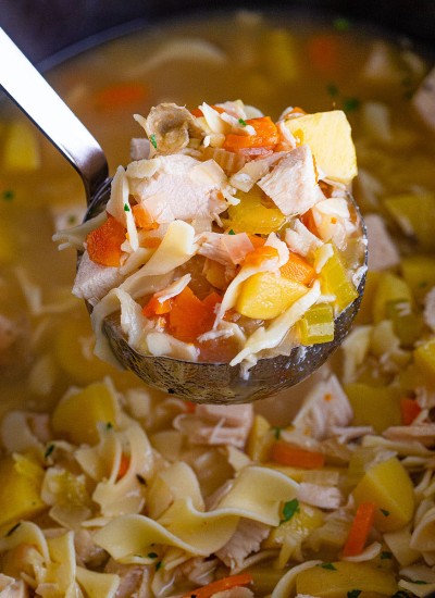 ladle scooping leftover turkey soup from the crockpot