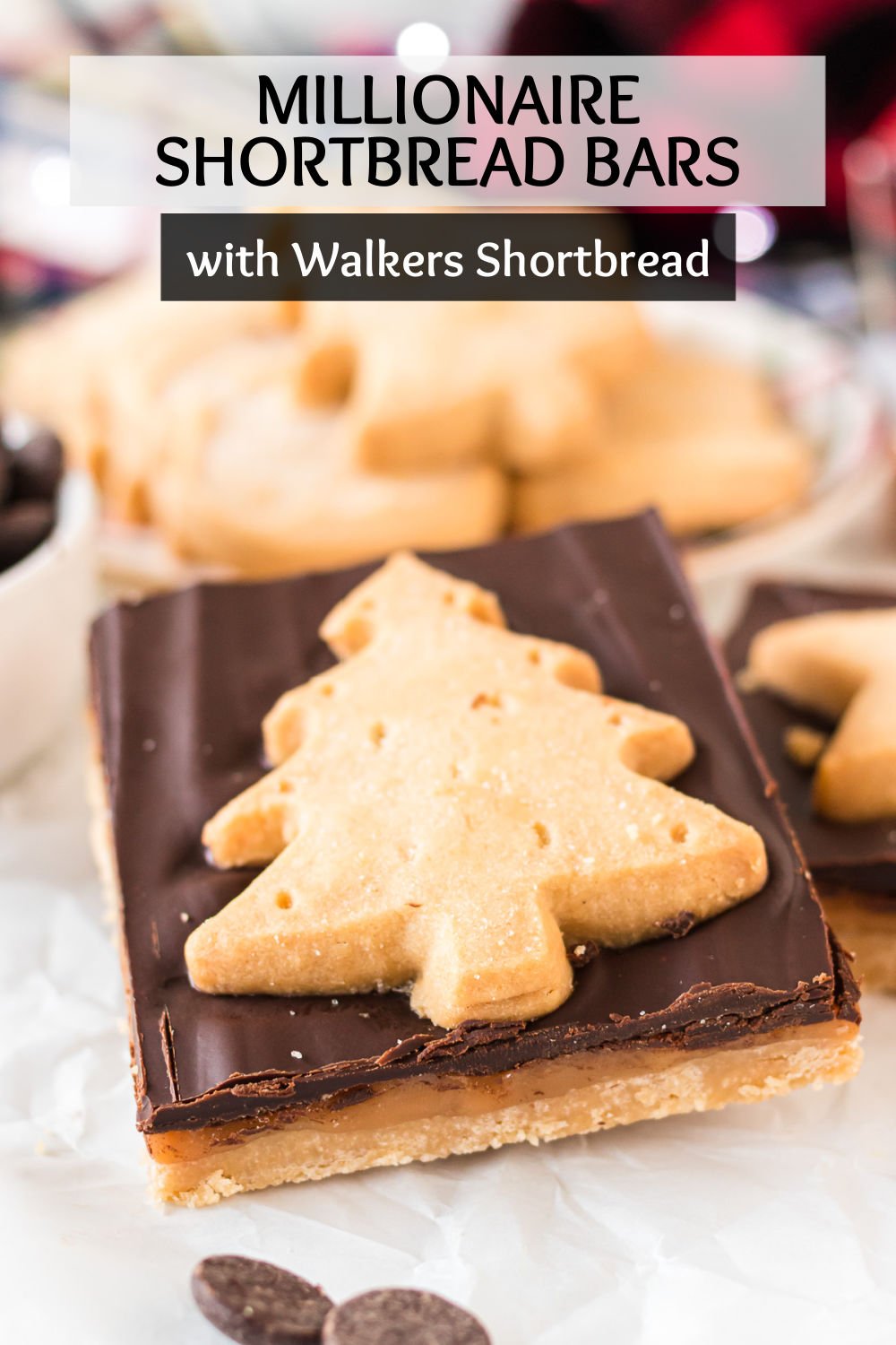 Millionaire Shortbread Bars - a layer of buttery shortbread made easy with Walkers Shortbread, topped with a gooey salted caramel layer, topped with a dark chocolate ganache, and finished with a Walkers Shortbread Festive Shape cookie pressed into the top. | www.persnicketyplates.com