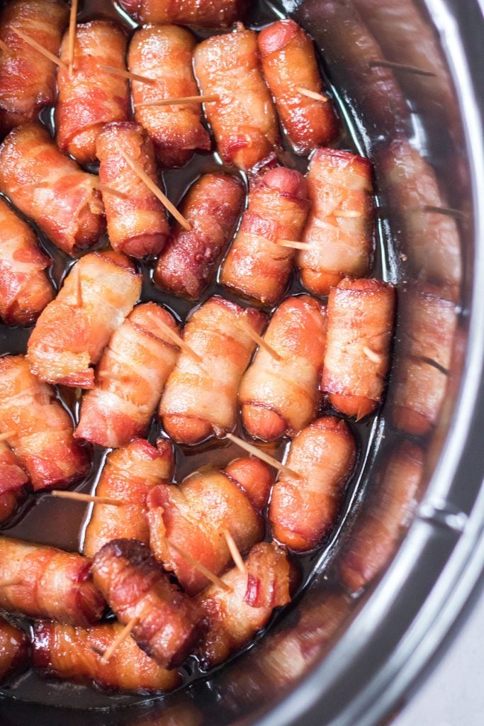 closeup of bacon wrapped smokies in a slow cooker bowl