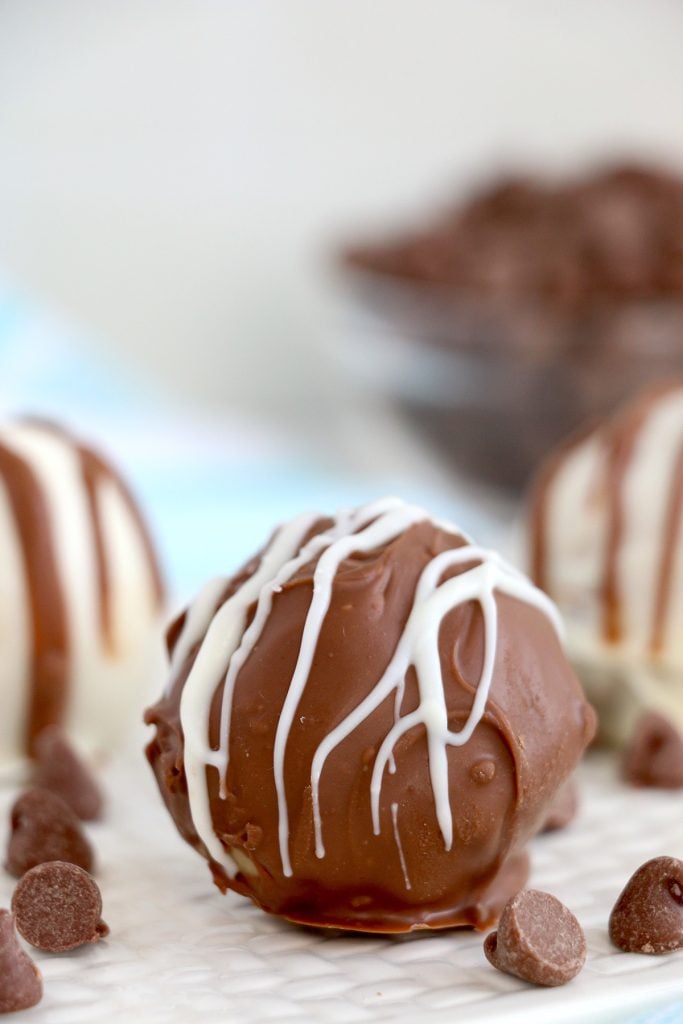 chocolate chip cookie dough truffle dipped in chocolate and drizzled with white chocolate