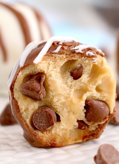 close up of a chocolate chip cookie dough truffle with a bite taken out of it