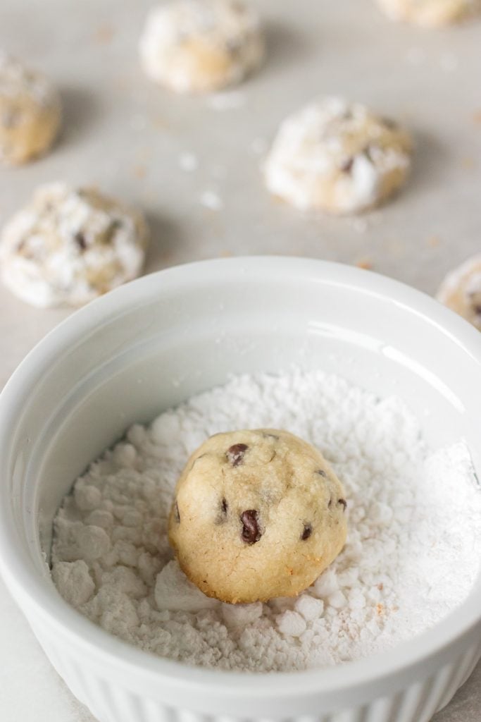 chocolate chip cookie sitting in a bowl of powdered sugar