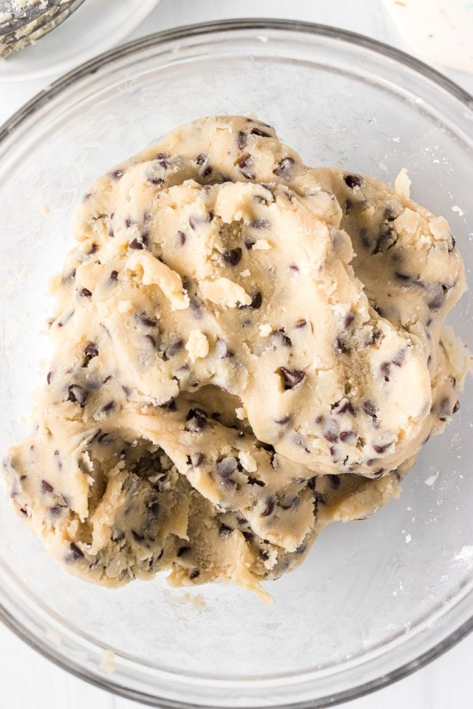 closeup of chocolate chip cookie dough in a glass mixing bowl