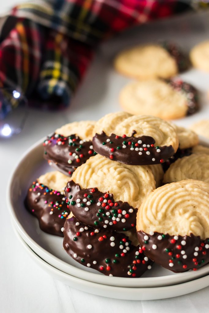 plate of butter cookies dipped in chocolate and topped with sprinkles