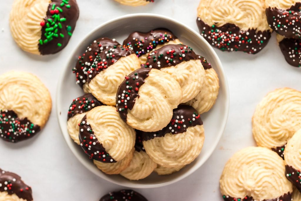 plate of festive chocolate dipped butter cookies with holiday sprinkles