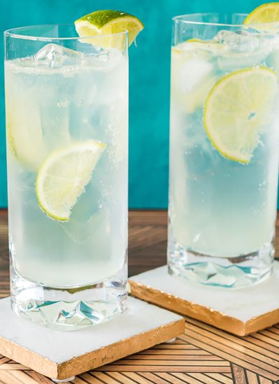 two ranch water cocktails with lime wedges on coasters