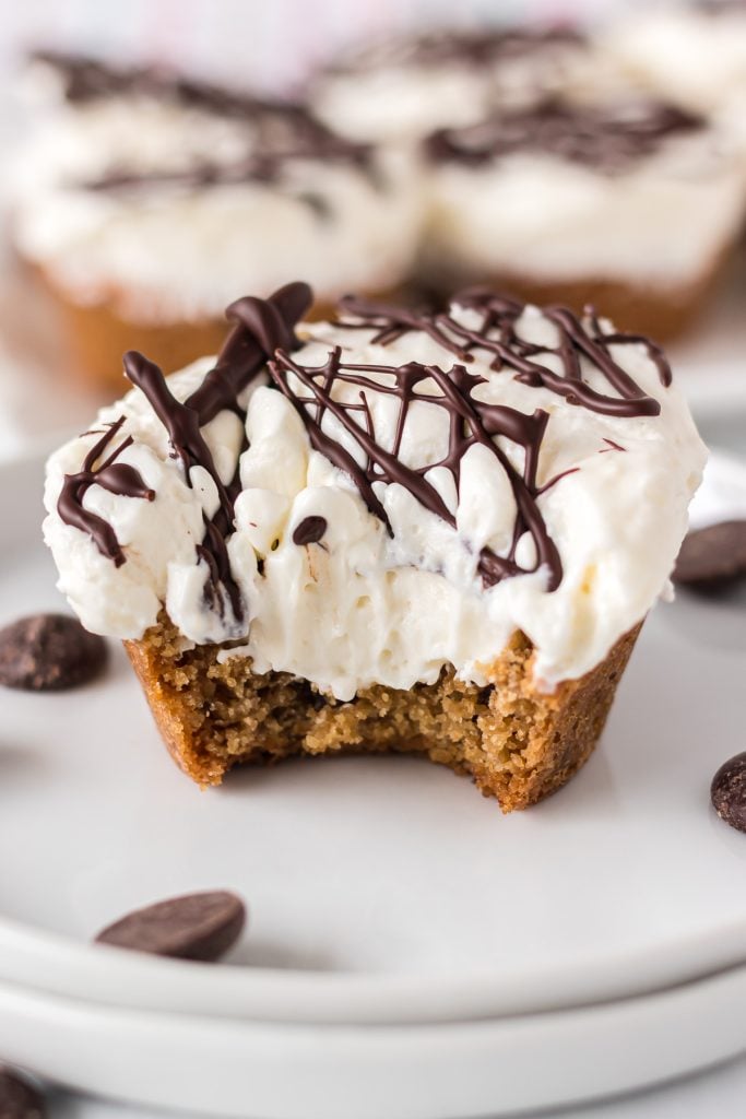 cheesecake cookie cup on a white plate with a bite missing.