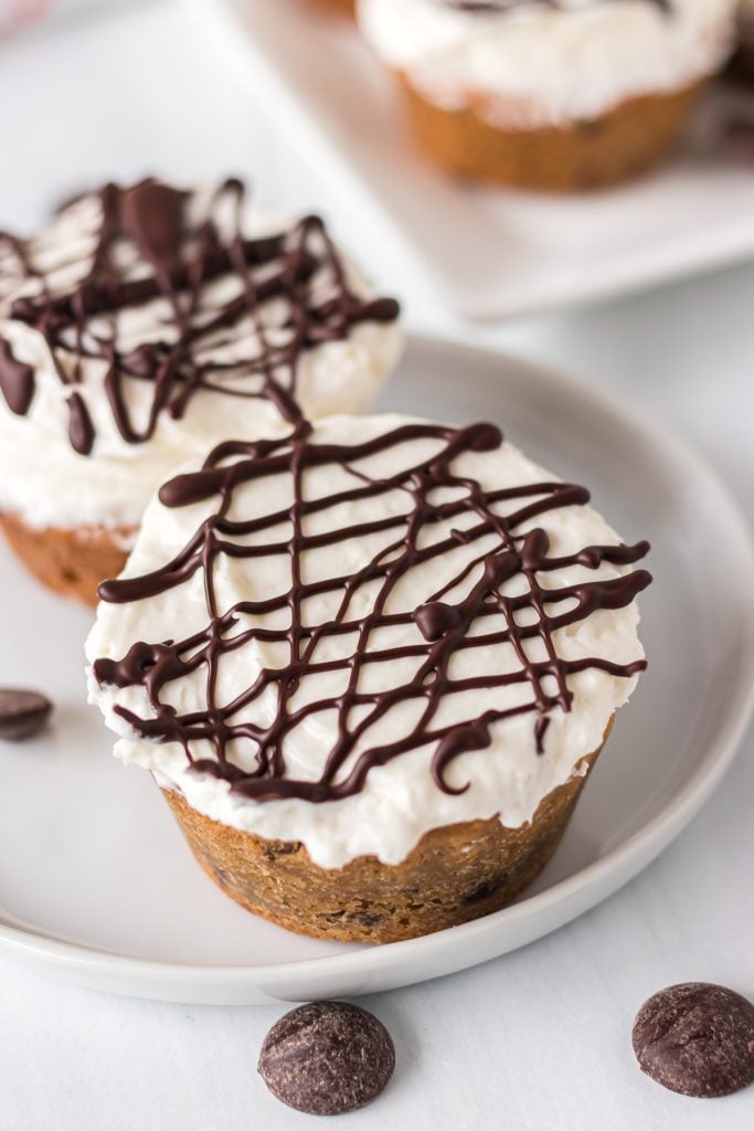 closeup of a cheesecake cookie cup drizzled with chocolate.