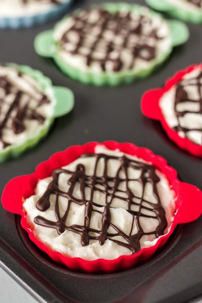 cupcake pan with chocolate drizzle cheesecake cookie cup.