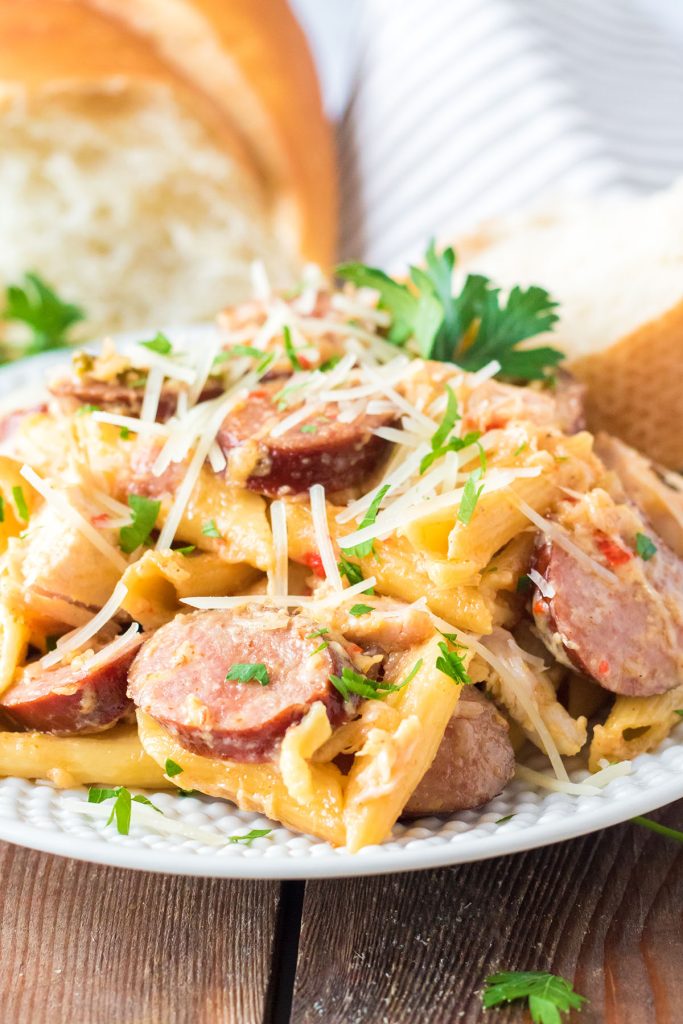 plate of cajun chicken pasta with sausage garnished with parsley.