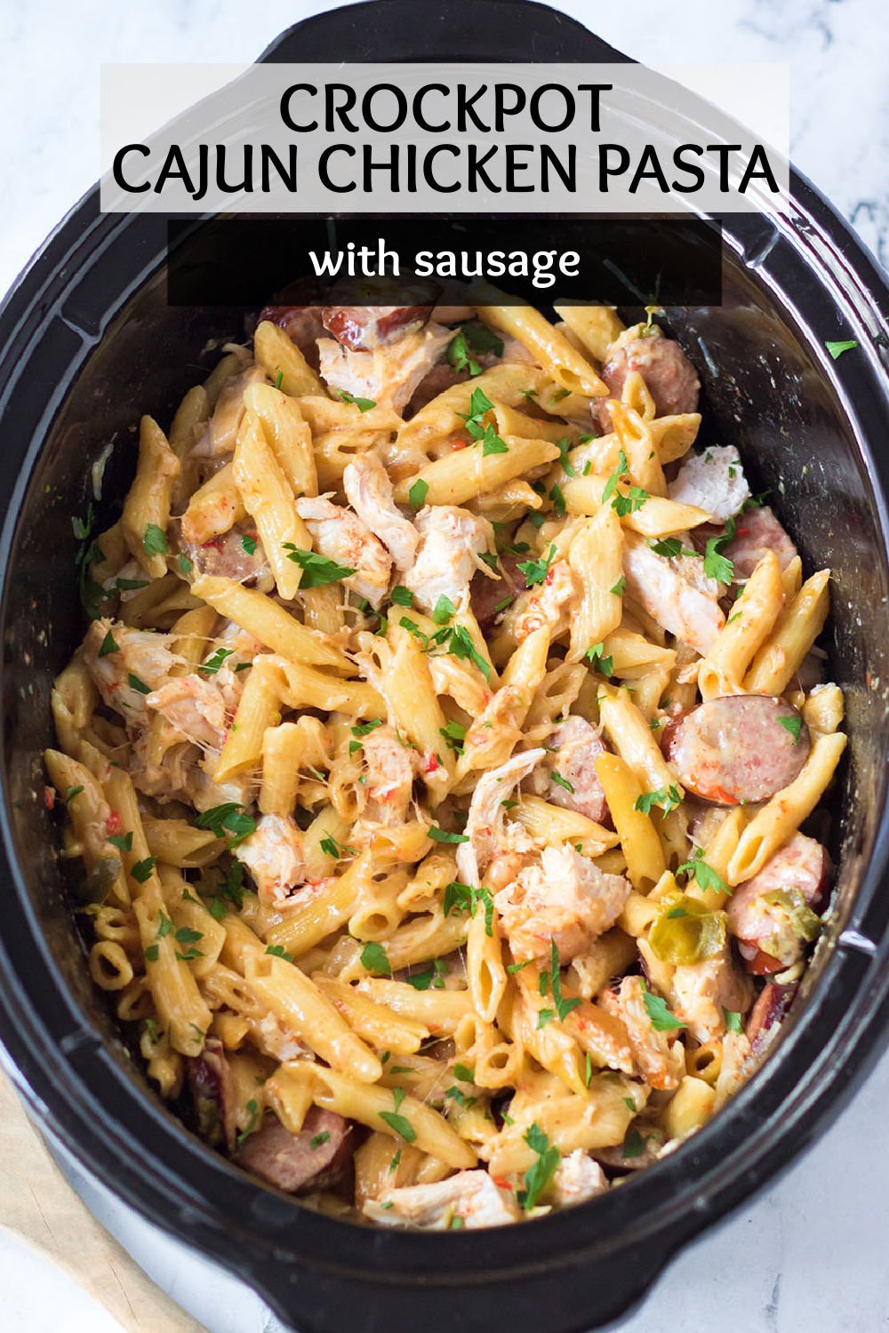 This Slow Cooker Cajun Chicken Alfredo is full of chicken, peppers, andouille sausage, and a creamy homemade alfredo sauce made right in your crockpot. | www.persnicketyplates.com