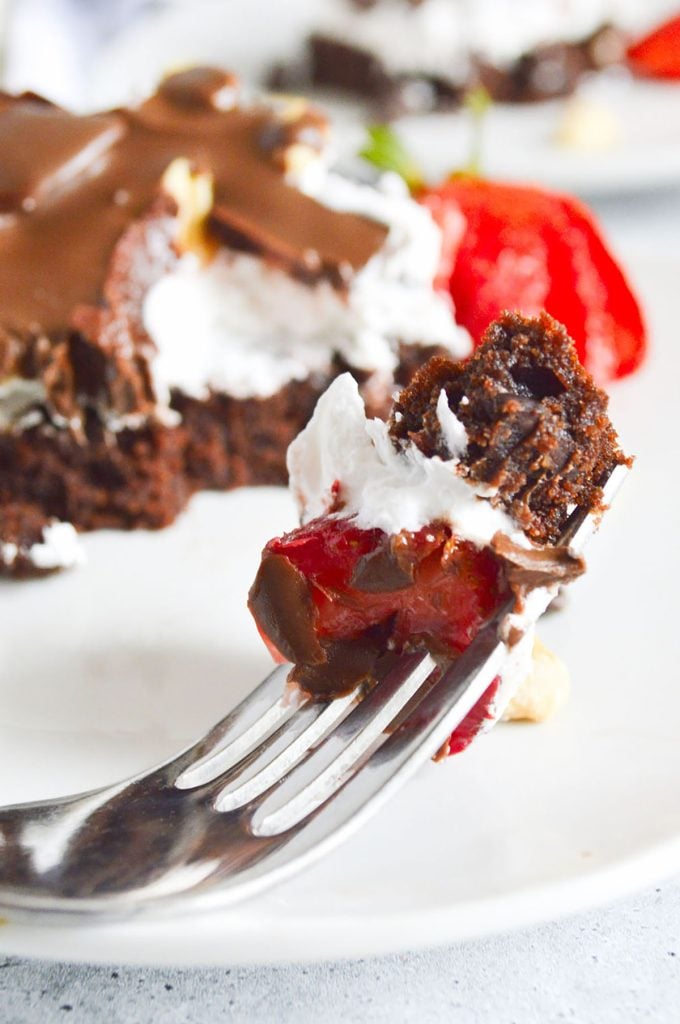 bite of brownie and whipped cream on a fork.