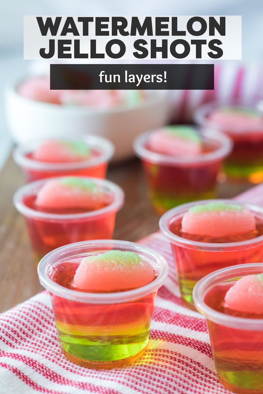 These easy layered watermelon jello shots are so good! Green and pink jello give these shots their watermelon look with a sour watermelon candy on top for fun! Perfect for a warm weather treat. | www.persnicketyplates.com