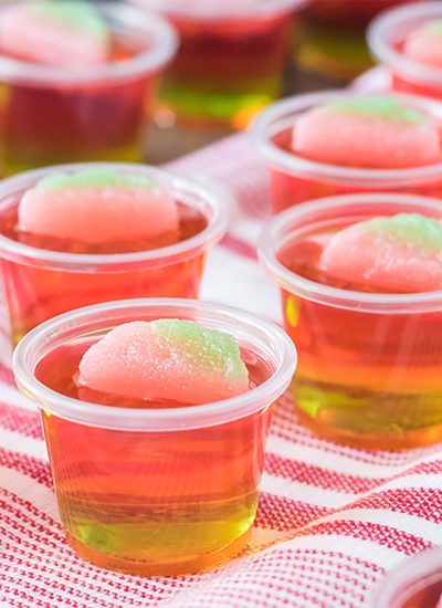 layered watermelon jello shot on a striped red towel.