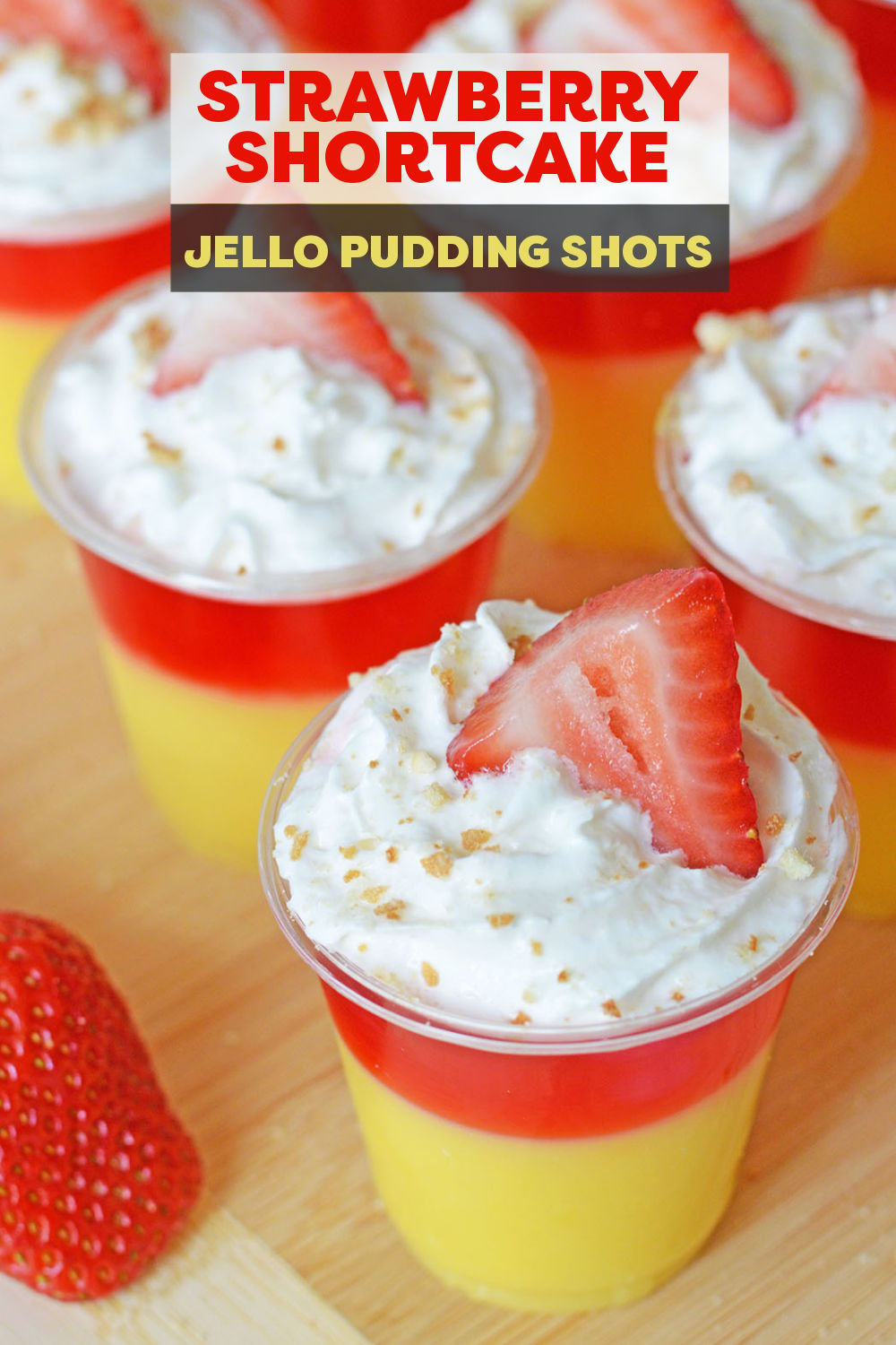 Layered strawberry shortcake jello shots are as pretty as they are delicious! These easy pudding shots are filled with vanilla pudding, strawberry jello, and are topped with whipped cream, a Nilla wafer, and fresh strawberries. | www.persnicketyplates.com