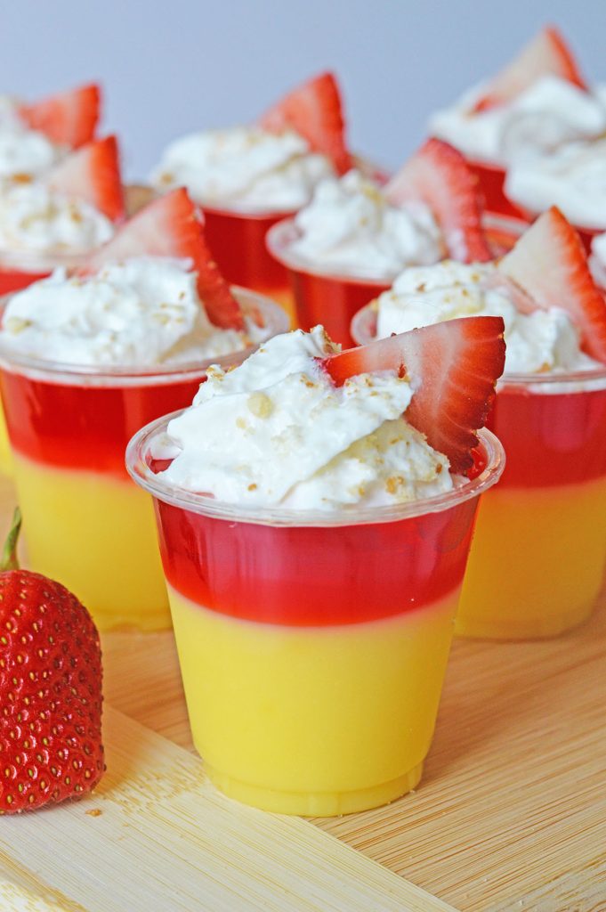strawberry shortcake pudding shots topped with whipped cream.