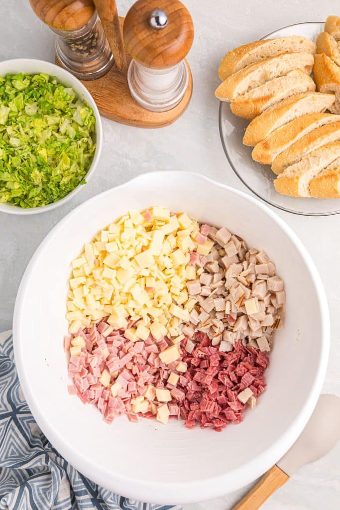 overhead shot of diced meats and cheeses in a mixing bowl.