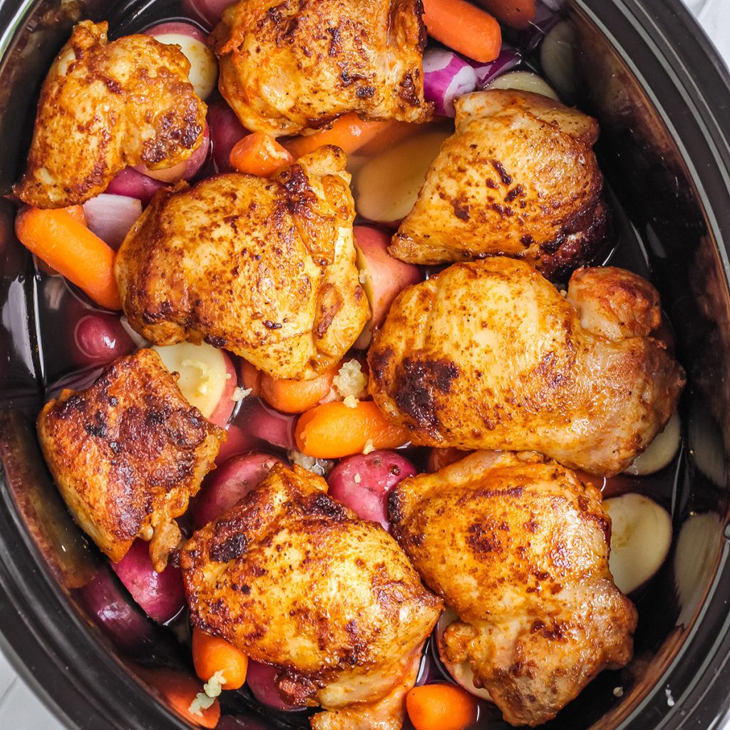 overhead shot of chicken, red potatoes, and carrots in a crockpot.