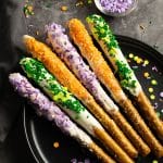 halloween pretzel rods with orange, green, and purple sprinkles.