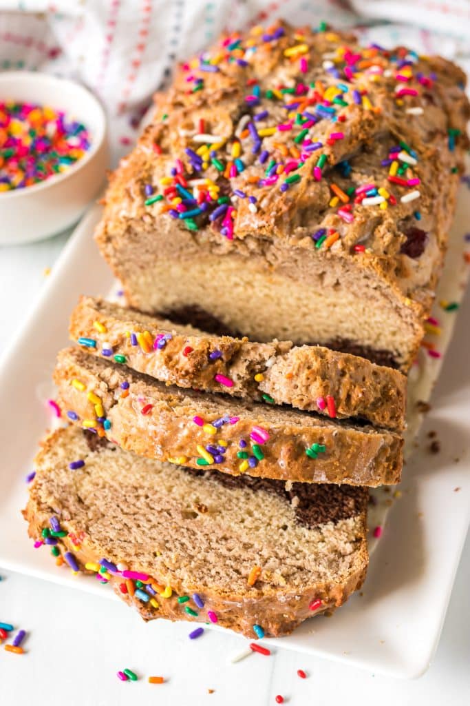 sliced loaf of ice cream bread topped with rainbow sprinkles.