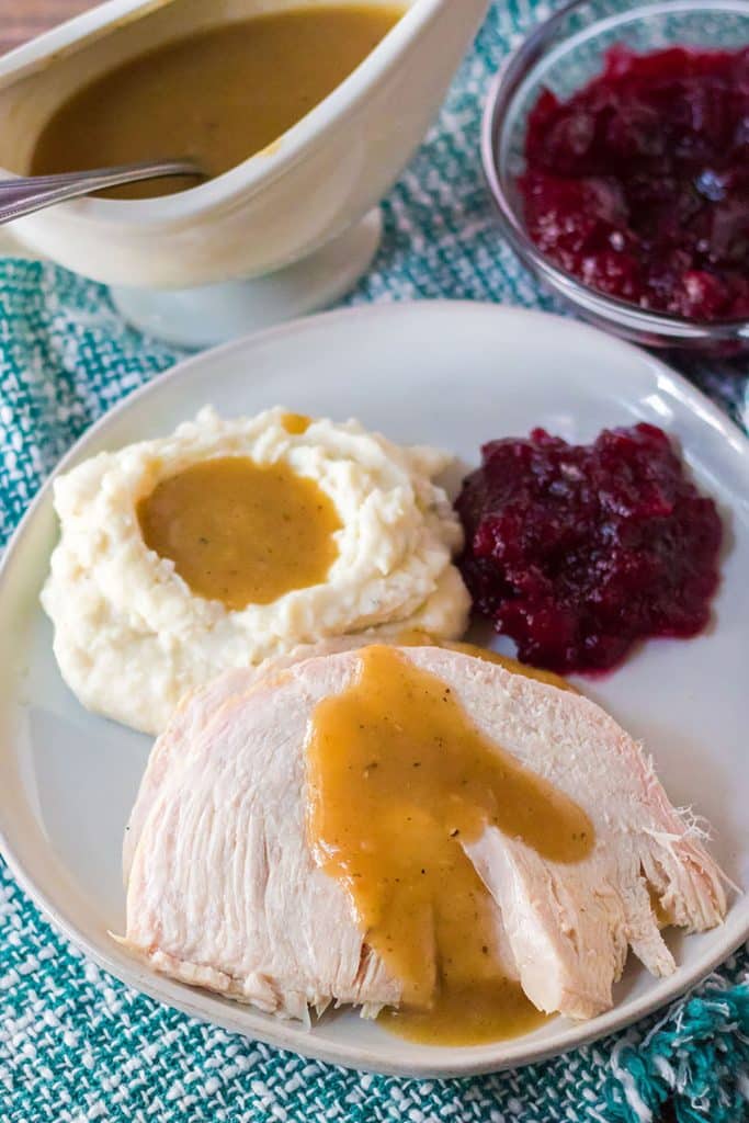 overhead shot of plate of turkey, gravy, mashed potatoes, and cranberry sauce.
