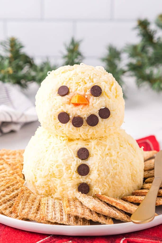 snowman cheese ball surrounded by crackers.