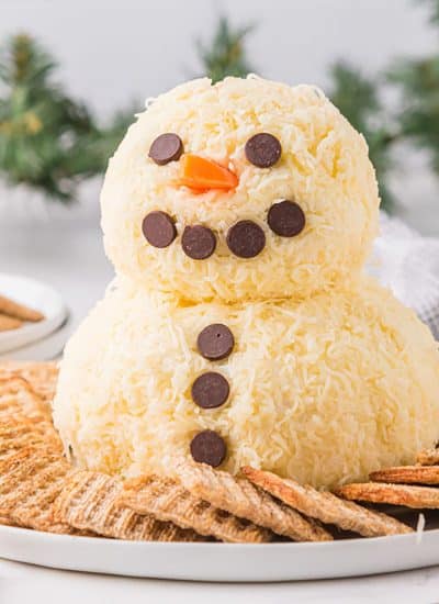 snowman cheeseball surrounded by crackers.