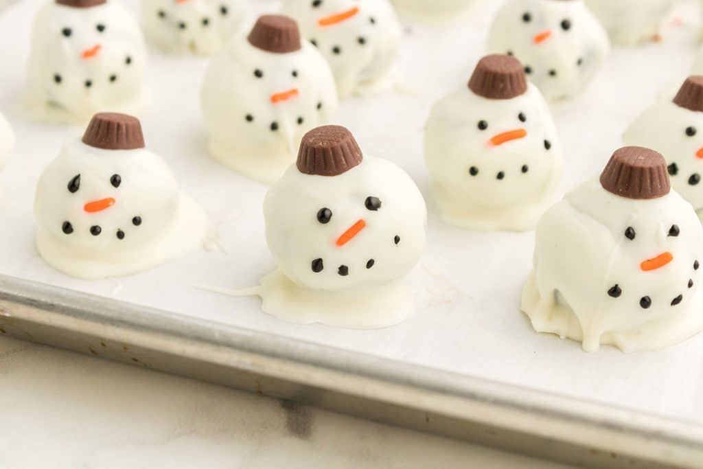 snowman oreo balls on a baking sheet.