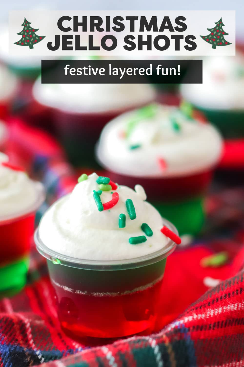 These Christmas Jello Shots are made with simple ingredients and will put the holiday spirit into your holiday season. Red and green jello are layered together then topped with whipped cream and festive sprinkles. Perfect for holiday parties! | www.persnicketyplates.com