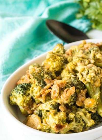 cheesy broccoli casserole in a white serving dish.