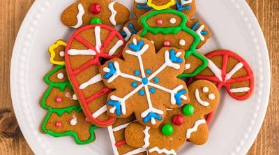 overhead shot of colorful decorated gingerbread cookies in holiday shapes.