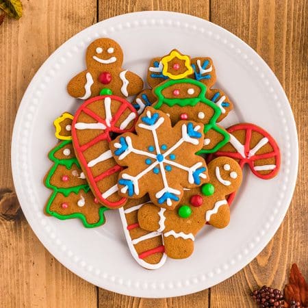 overhead shot of colorful decorated gingerbread cookies in holiday shapes.