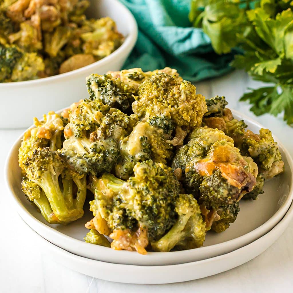 cheesy broccoli casserole on a white plate.